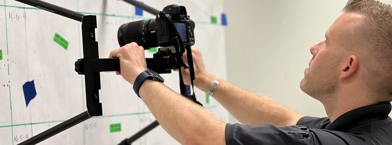 Man uses digital camera to photograph diagrams on wall